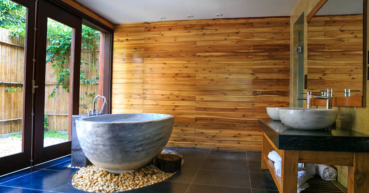 Elegant bathroom showcasing a modern marble tub and wooden interior for a serene escape.