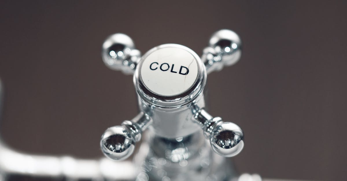 Elegant close-up of a chrome bathroom faucet with a cold water handle, offering a modern touch.