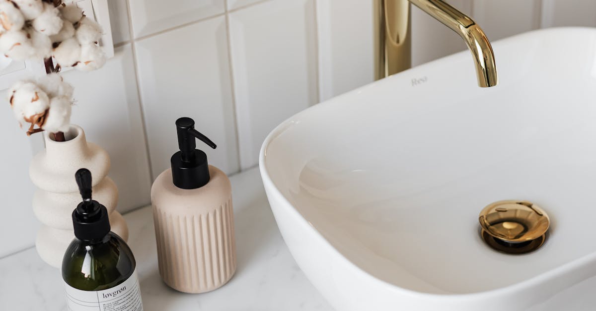 Stylish bathroom vanity featuring a ceramic sink, gold faucet, and spa-like accessories.