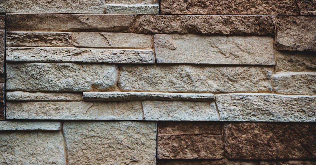A detailed close-up of a rustic, weathered stone tiled wall pattern.