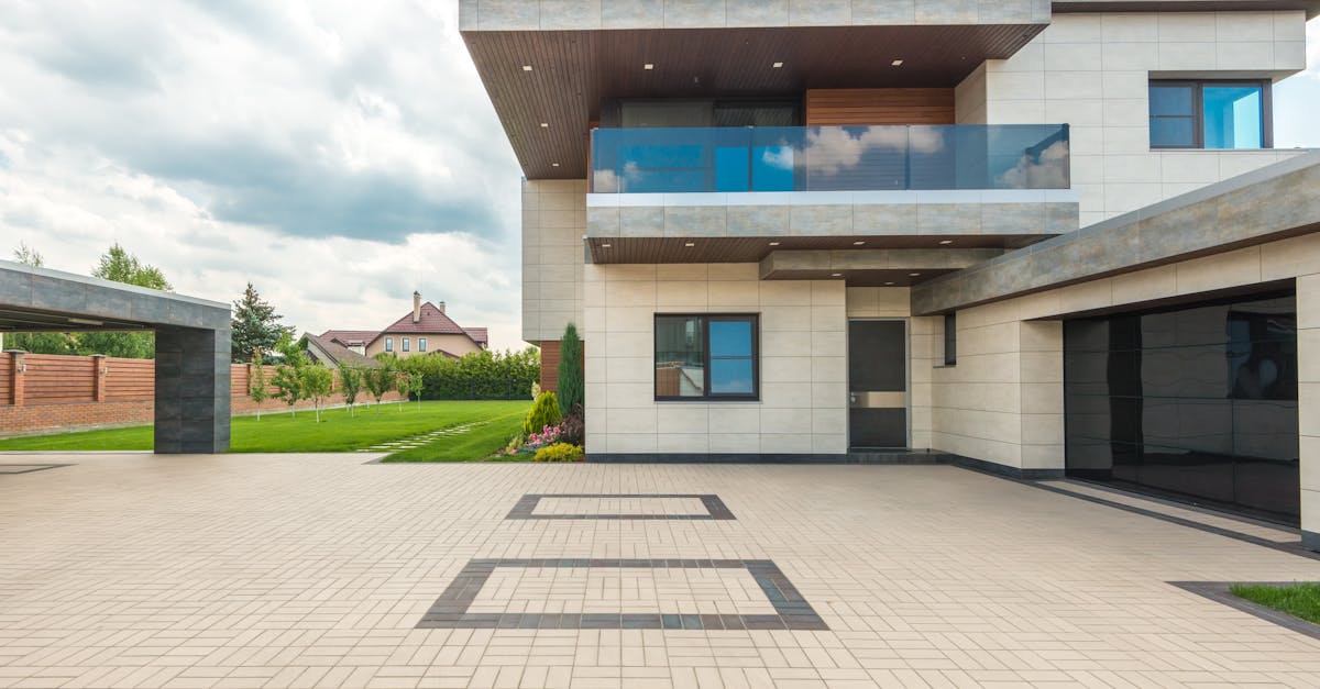 Stylish modern house featuring a sleek design with a large driveway and lush greenery.